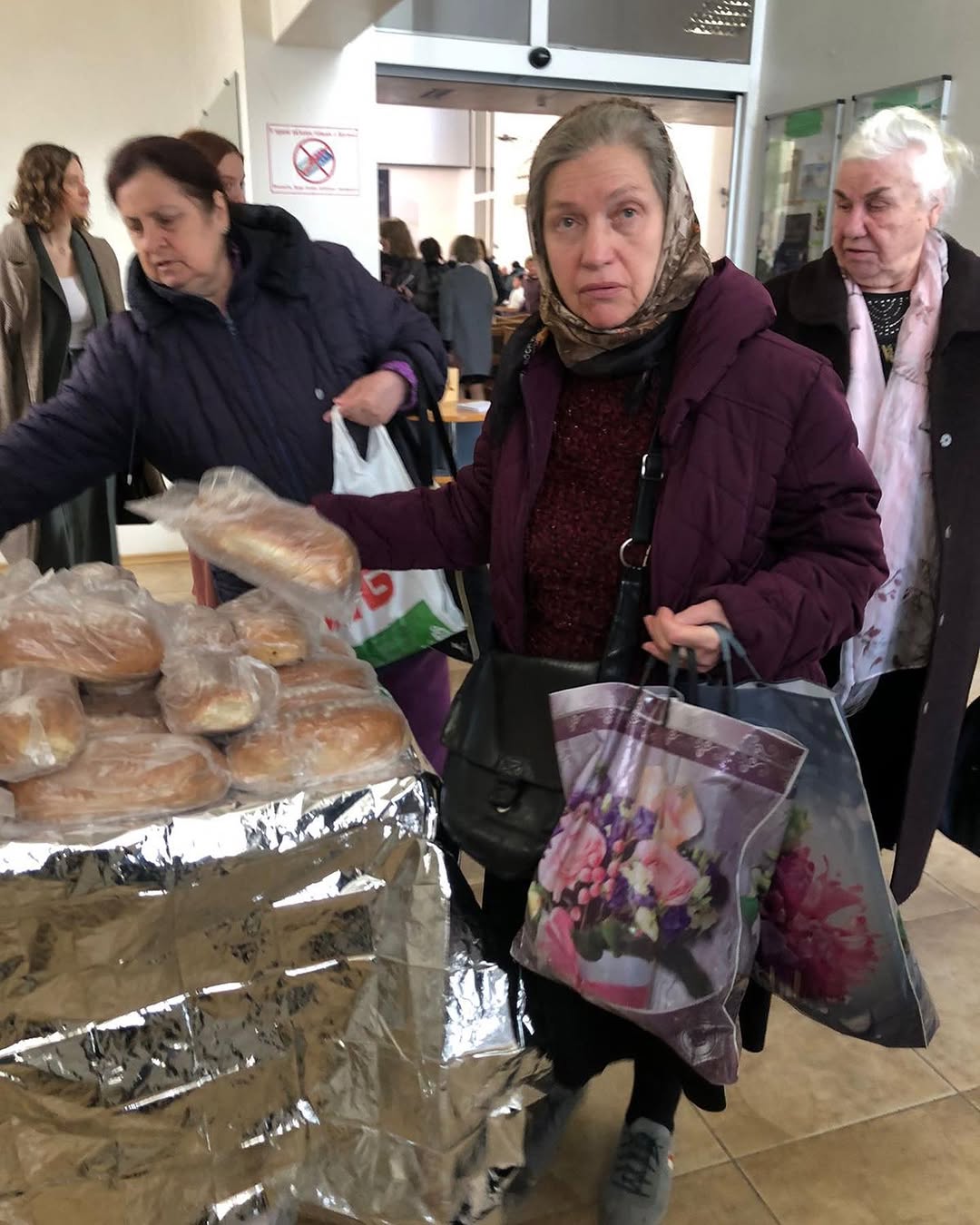 Seniorinnen nehmen in einer Kiewer Kirche frisches Brot entgegen